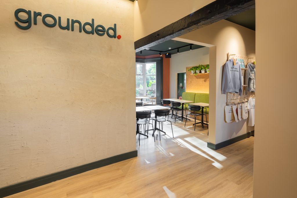 The entrance to grounded. café in Selly Oak, showing interior signage and merchandise design