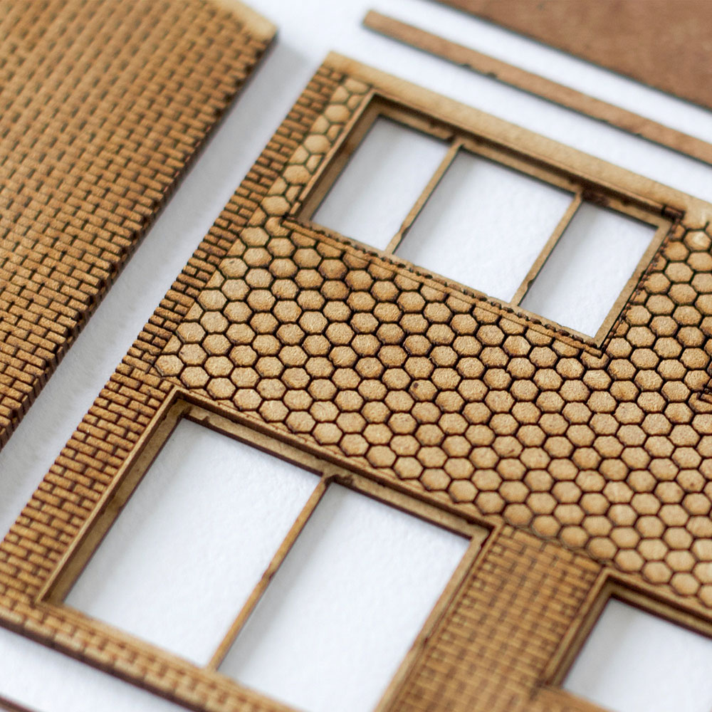 Close-up of an MDF laser cut model of a 1960's style small house, showing detail of the tiling pattern.